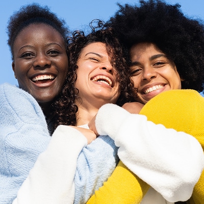 photo of 3 women hugging power of touch for longevity benefits